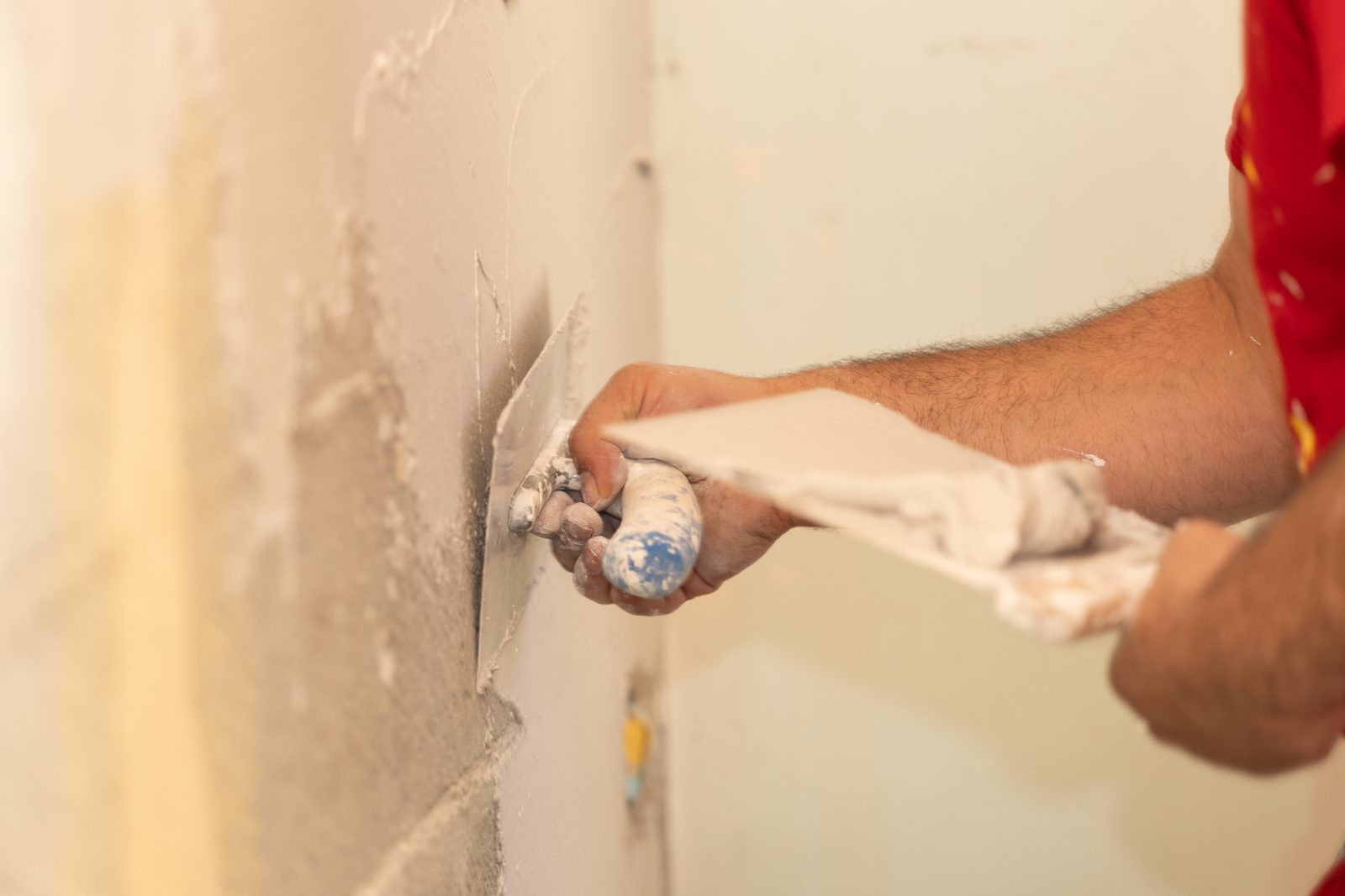 Plâtrier lissant les murs à la taloche sur le chantier de La Bergère